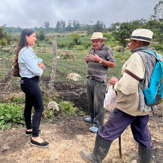 Agricultor interactuando con un técnico de Merco Riego en el campo, destacando el apoyo a las comunidades agrícolas.